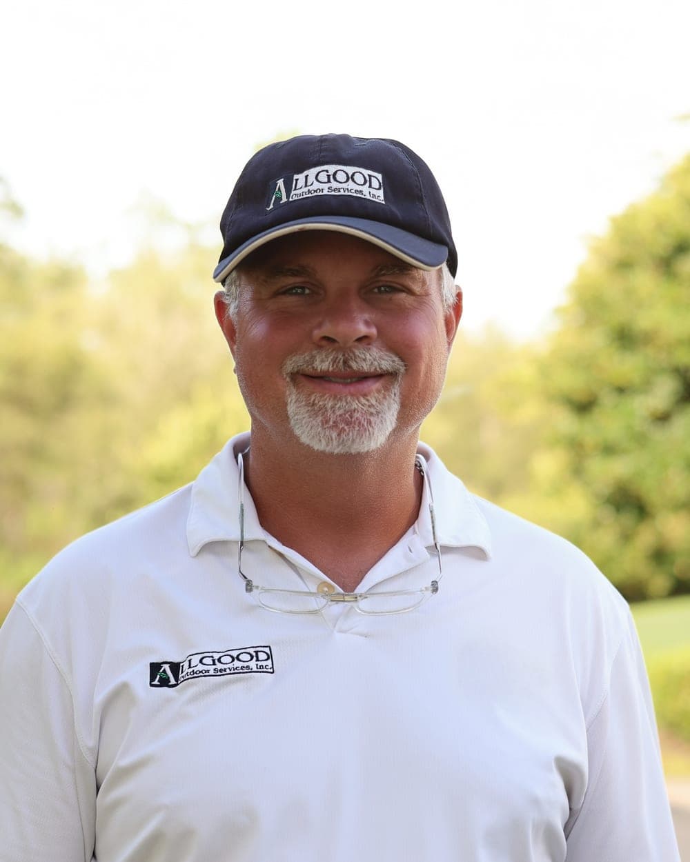Duncan, owner of Allgood Outdoor Services, in an Allgood cap and polo shirt outdoors